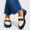 Mocasín bicolor azul marino y gris de Vega Madrid, calzado cómodo para mujer, en un fondo neutro.