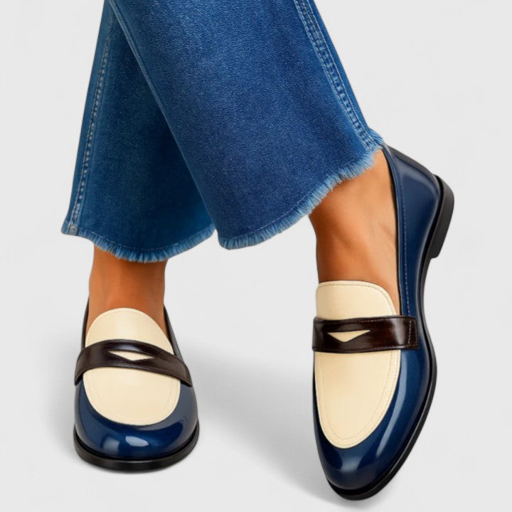 Mocasín bicolor azul marino y gris de Vega Madrid, calzado cómodo para mujer, en un fondo neutro.