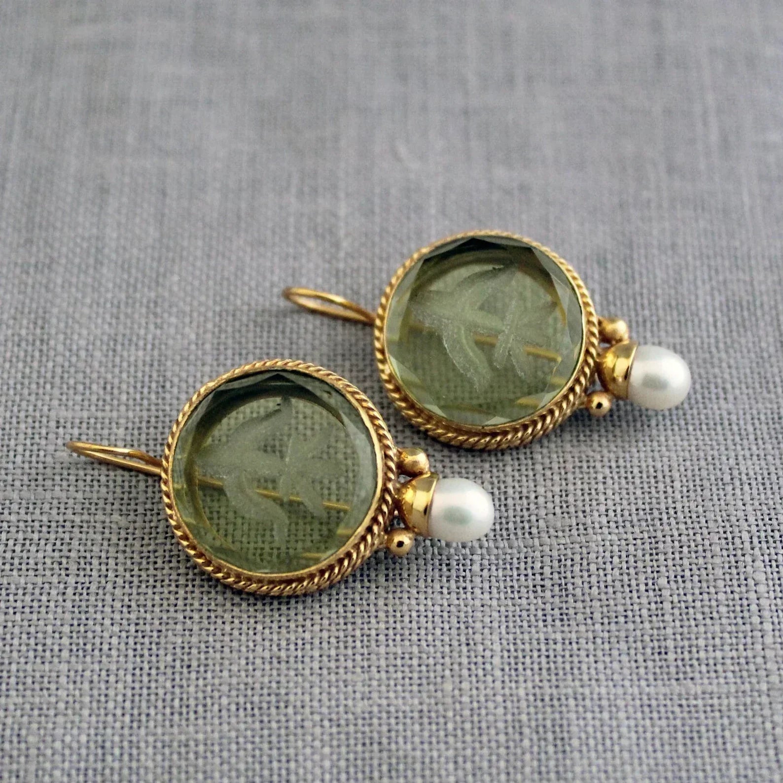 Pendientes premium Penelope de Vega Madrid, diseño elegante con detalles metálicos y acabado brillante sobre fondo neutro.