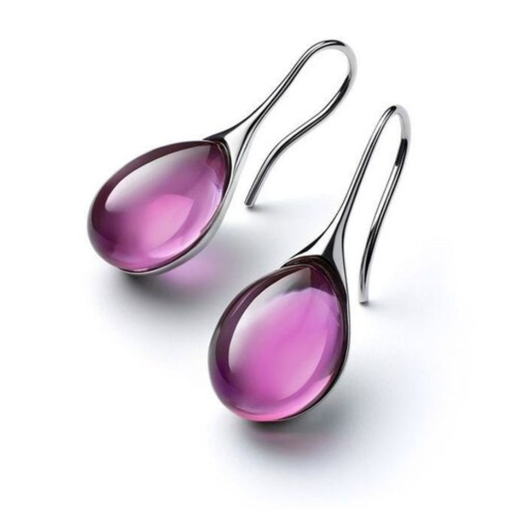 Pendientes colgantes dorados y plateados de Vega Madrid, con diseño creativo y detalles elegantes sobre fondo neutro.