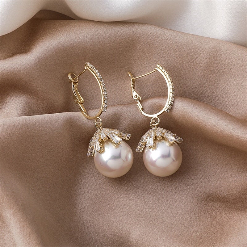 Pendientes colgantes de perla Malia de Vega Madrid, con diseño elegante y detalles en perla blanca.