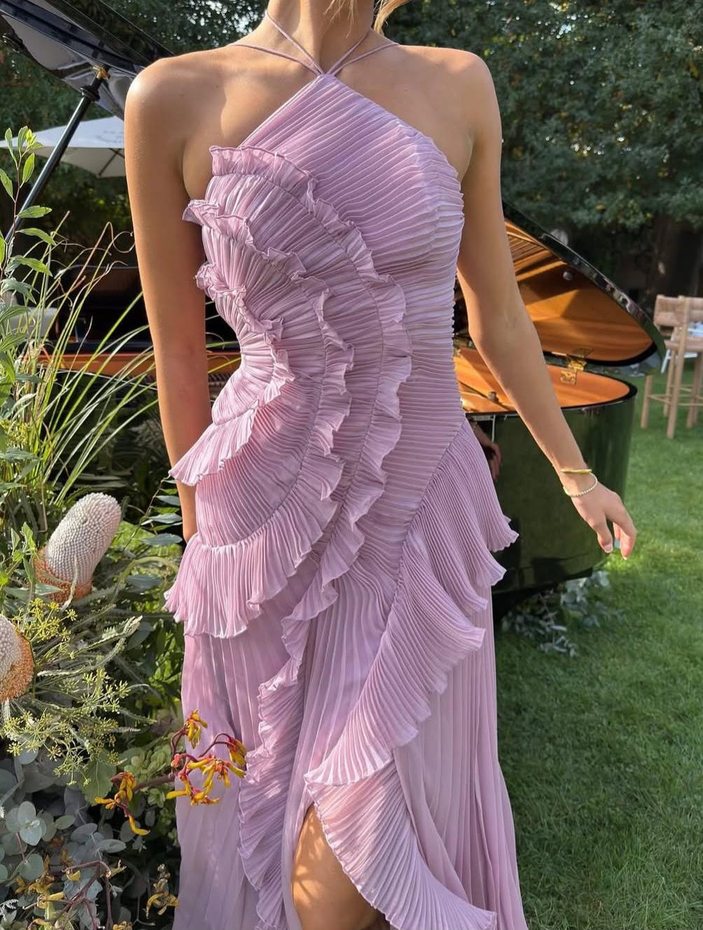 Vestido elegante Isadora de Vega Madrid con volantes y corte asimétrico, mostrando detalles de la prenda en color neutro.