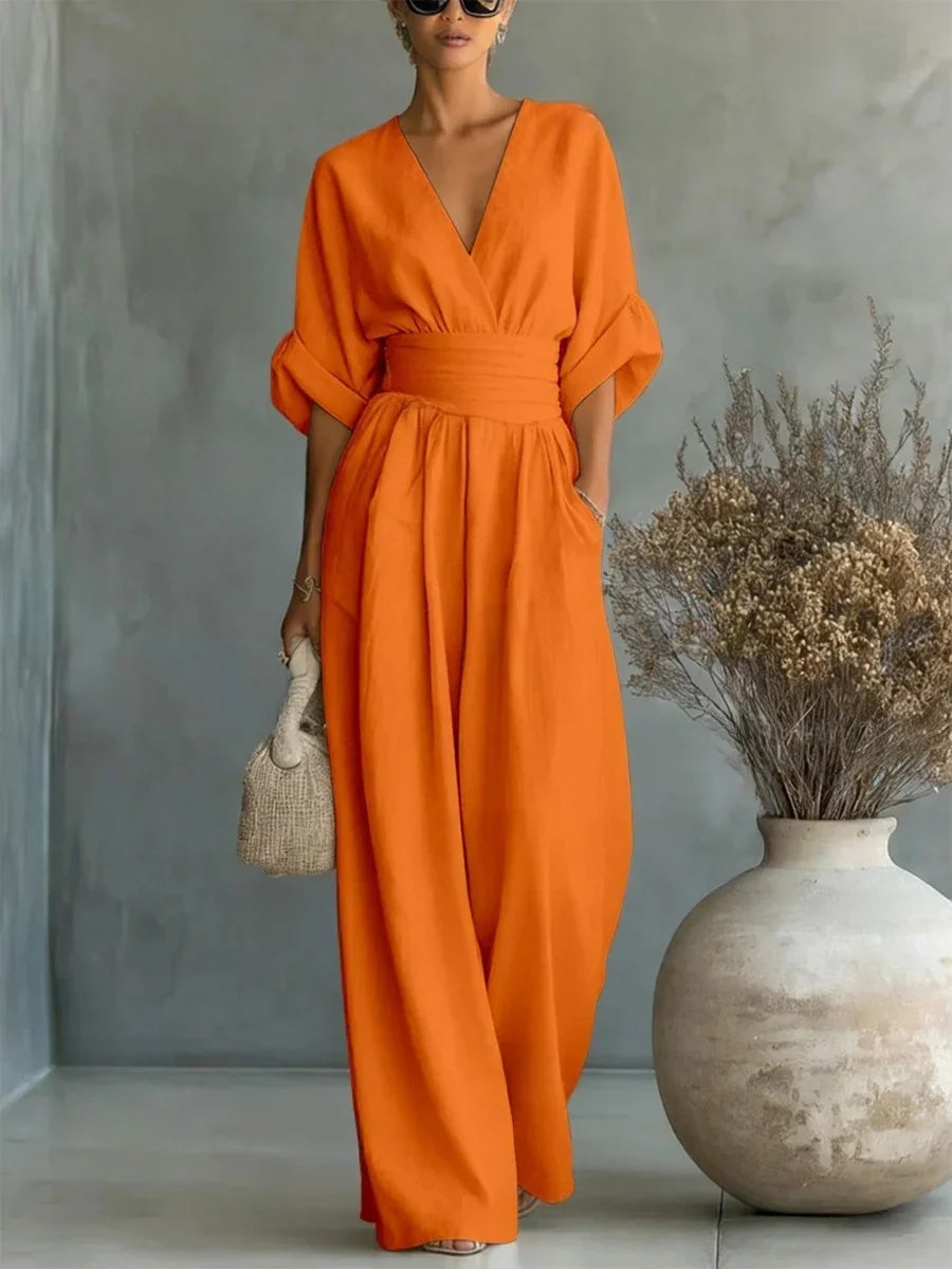 Muñeco de Belén con mono naranja de Vega Madrid, elegante, con cuello en V y cintura alta, en fondo blanco.