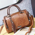 Bolso de piel Monique de Vega Madrid, textura de cuero, con asas cortas y detalles elegantes, en color neutro.