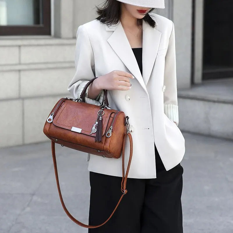 Bolso de piel Monique de Vega Madrid, textura de cuero, con asas cortas y detalles elegantes en la superficie del bolso.