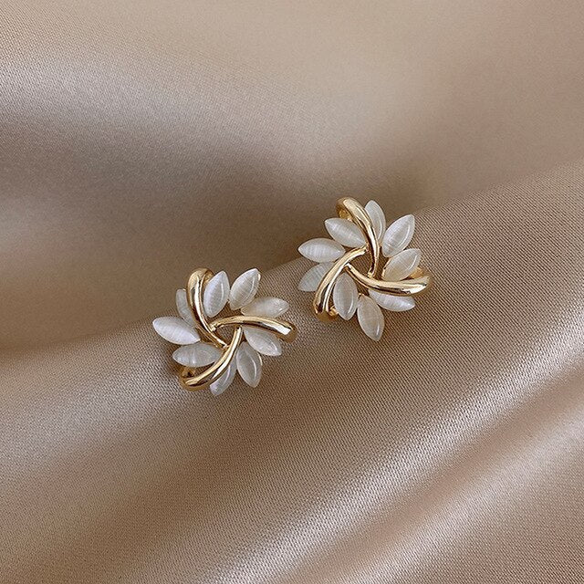 Pendientes de tuerca en forma de círculo con detalles de pátalos de palo para mujer, joyería Vega Madrid, estilo elegante y moderno.