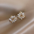 Pendientes de tuerca en forma de círculo con detalles de pátalos de palo para mujer, joyería Vega Madrid, estilo elegante y moderno.