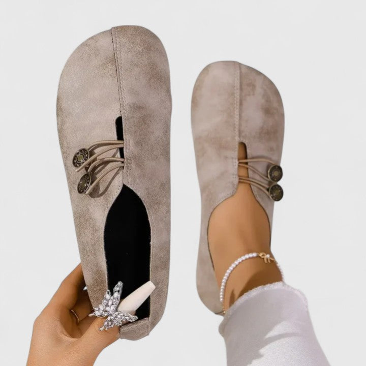 Zapatos planos Kyline de Vega Madrid en color arena con botón, vista lateral en estilo elegante y cómodo.