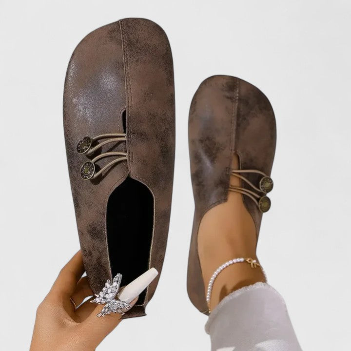 Zapatos planos Kyline de Vega Madrid en color arena con botón, diseñados para comodidad y estilo en calzado femenino.