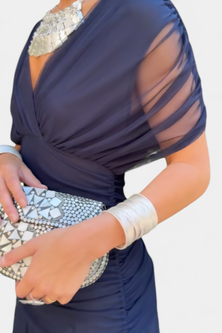 Vestido largo celeste con escote cruzado y tejido fluido, diseñado por Vega Madrid, mostrado en la imagen.