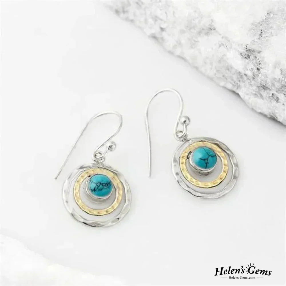 Pendientes boho Saturno de Vega Madrid con piedra turquesa, detalles en oro y plata, estilo elegante y moderno