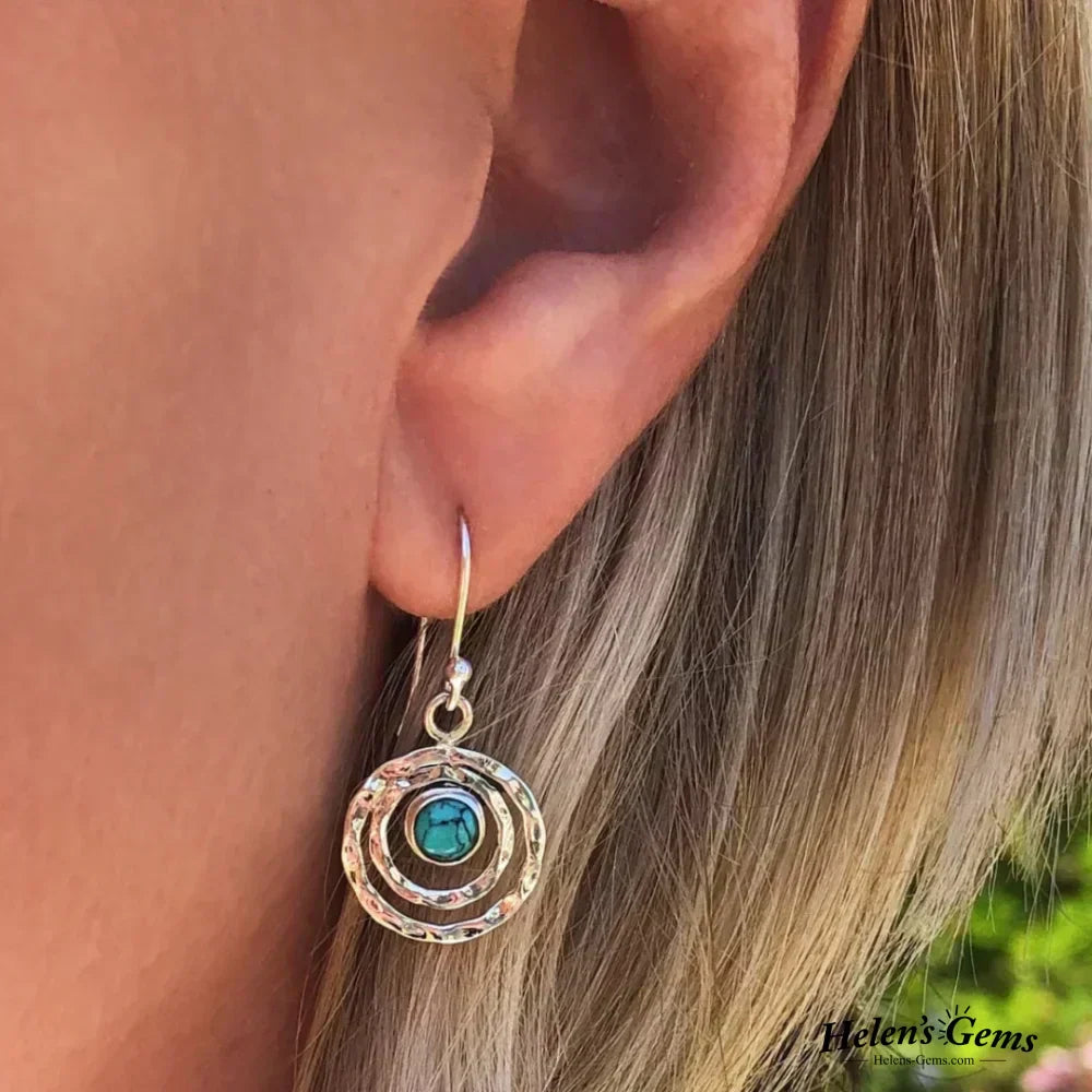 Pendientes boho Saturno de Vega Madrid con piedra turquesa, detalles en oro y plata, estilo elegante y moderno.