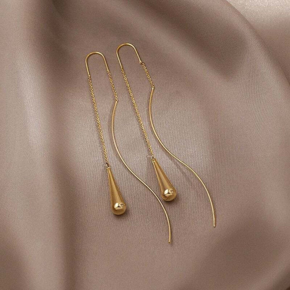 Pendientes colgantes dorados con flecos de Vega Madrid, diseño elegante y moderno para ocasiones especiales.