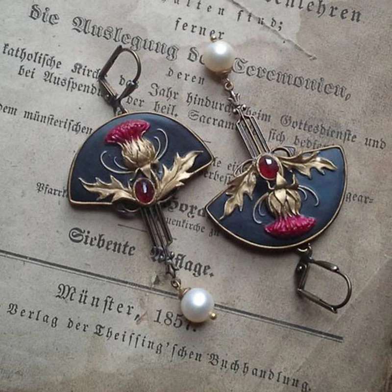 Pendientes boho de Vega Madrid con perlas blancas y cristales rojos, diseño elegante y moderno para ocasiones especiales.