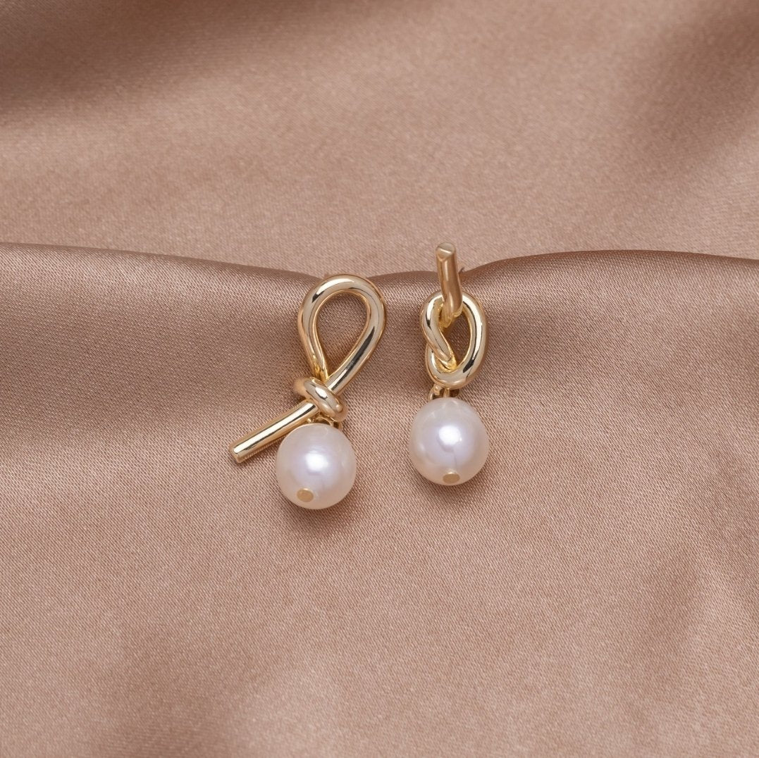Pendientes dorados con nudo y perlas de agua dulce de Vega Madrid, accesorios elegantes y delicados para mujer.