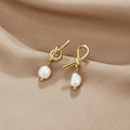 Pendientes dorados con nudo y perlas de agua dulce de Vega Madrid, detalles elegantes en forma de aro con perlas blancas naturales.