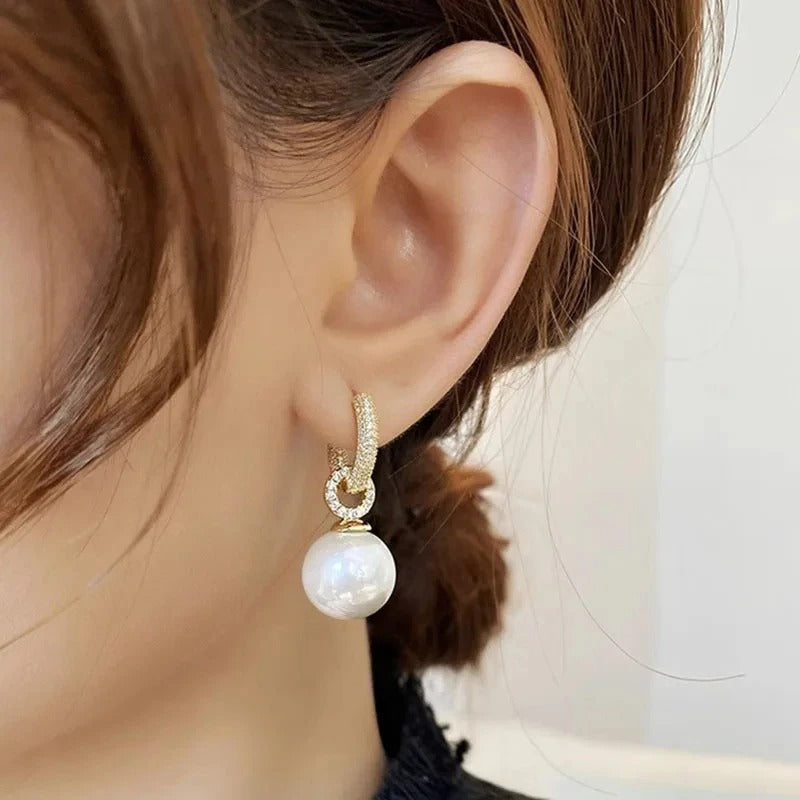 Pendientes elegantes con perlas blancas y detalles dorados de Vega Madrid, mostrando su diseño sofisticado y acabado brillante.