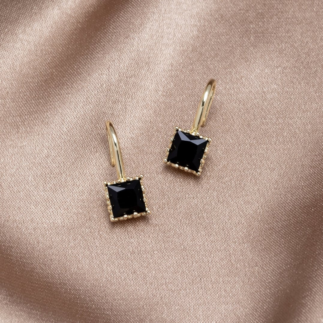 Pendientes colgantes Wonder Crystal de Vega Madrid con cristales negros y diseño elegante sobre fondo blanco