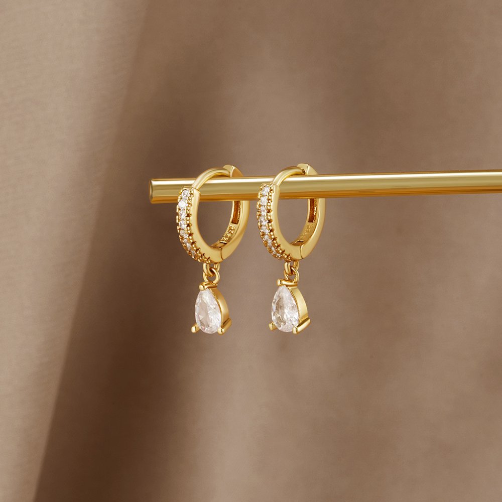 Pendientes de aro dorados con cristales blancos y marfil, de la marca Vega Madrid, con acabado brillante y elegante.